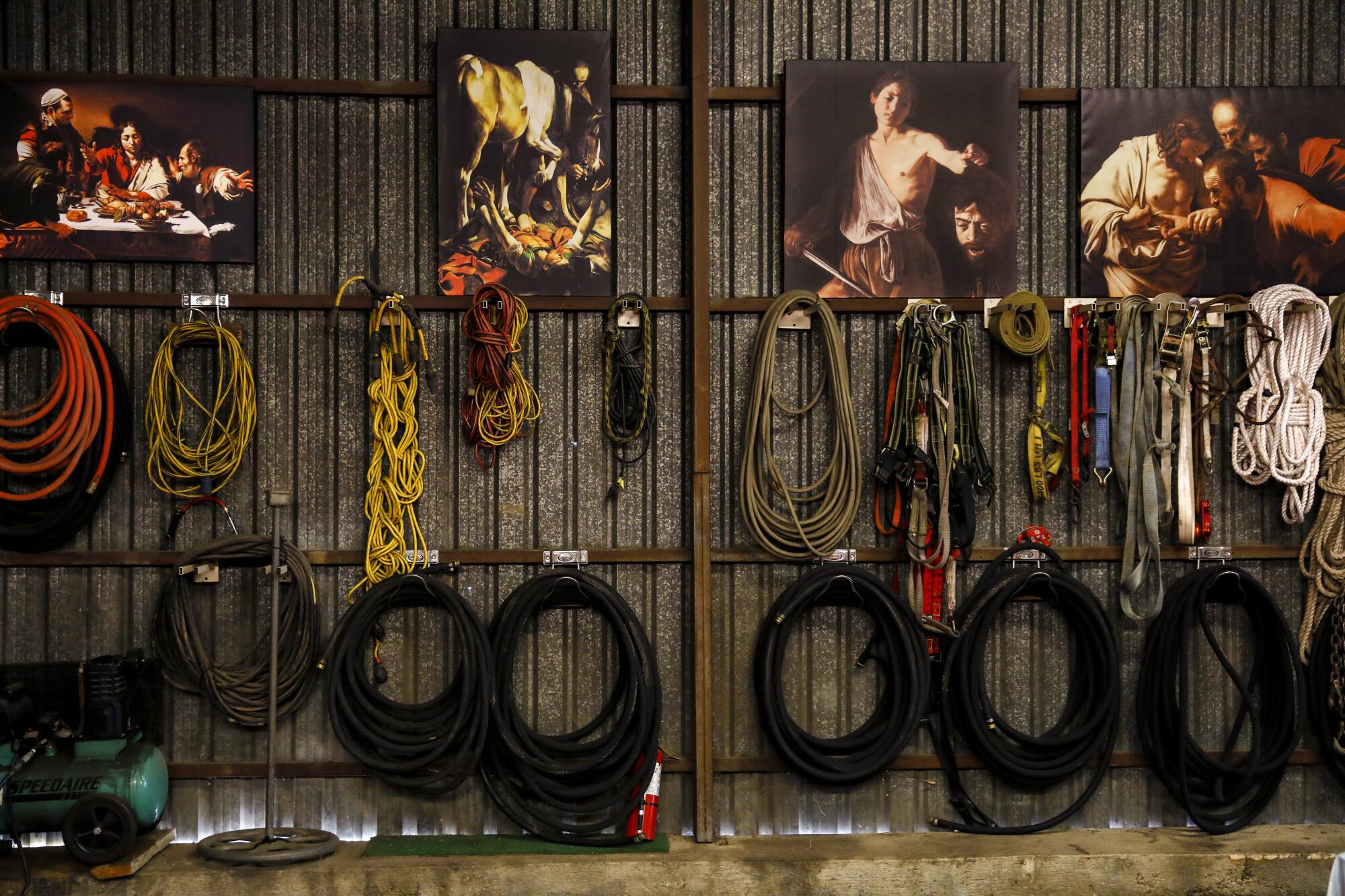 Replicas of paintings by Renaissance artist Caravaggio line the landscaping shop walls above neatly coiled hoses and ropes.