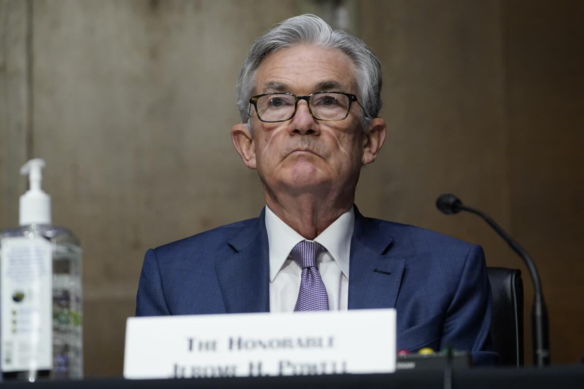 Jerome Powell sits behind a microphone and a name plaque.