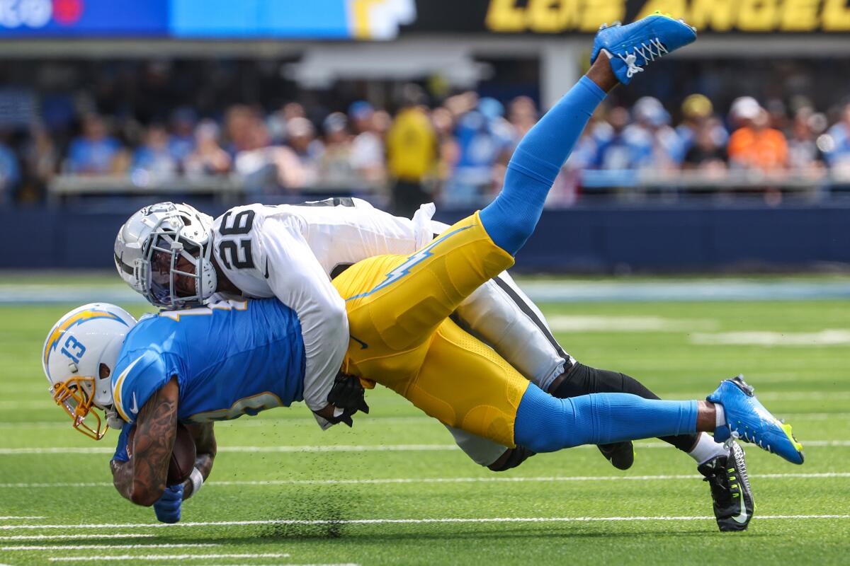 Chargers wide receiver Keenan Allen (13) is tackled by Las Vegas Raiders cornerback Rock Ya-Sin (26) in the first first half.