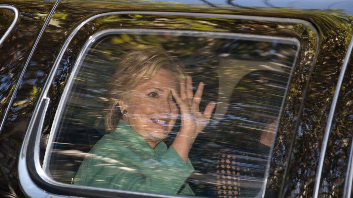 Democratic presidential candidate Hillary Clinton waves from her motorcade in Los Angeles on Aug. 23.