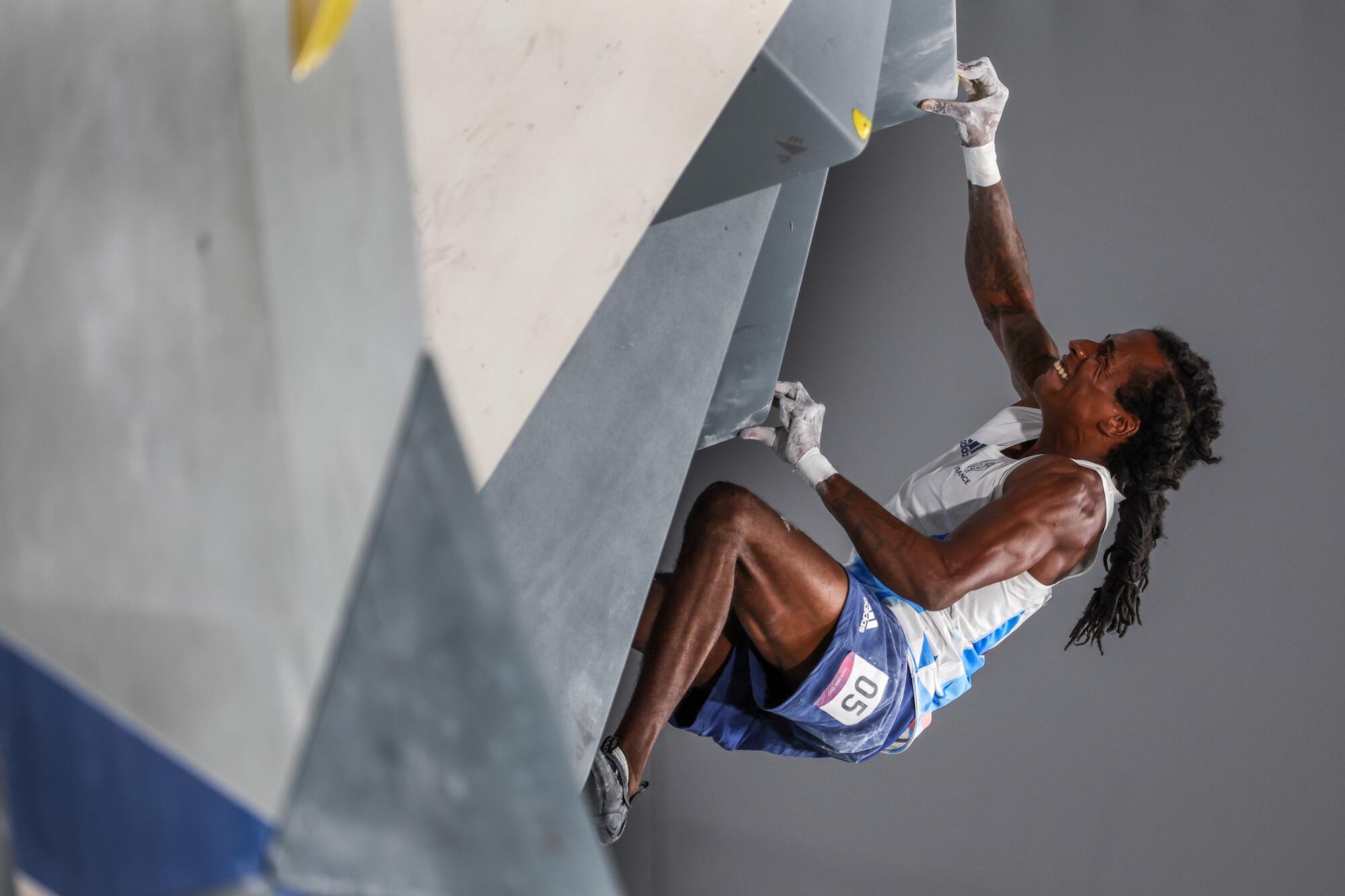 French climber Mikael Mawem uses his fingers to get him through a tough part of the Men's Combined Bouldering Final.