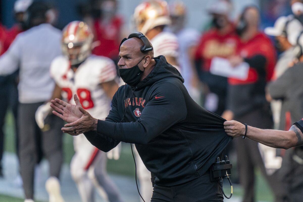FILE - In this Nov. 1, 2020, file photo, San Francisco 49ers defensive coordinator Robert Saleh cheers on his team from the sideline during the first half of an NFL football game against the Seattle Seahawks in Seattle. One year ago, Saleh and Kansas City Chiefs offensive coordinator Eric Bieniemy missed out on the coaching carousel despite being coordinators of the two Super Bowl teams. The two figure to be near the top of many of the lists of possible head coaching candidates again this offseason when the NFL is hoping some new rules lead to more opportunities for minority coaches.(AP Photo/Stephen Brashear, File)