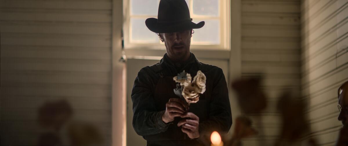 Benedict Cumberbatch wears a cowboy hat and holds flowers