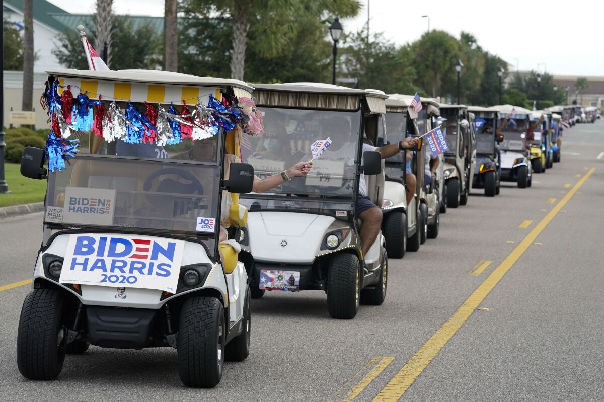 A parade of Biden supporters ride golf carts to an elections office to cast their ballots in The Villages.