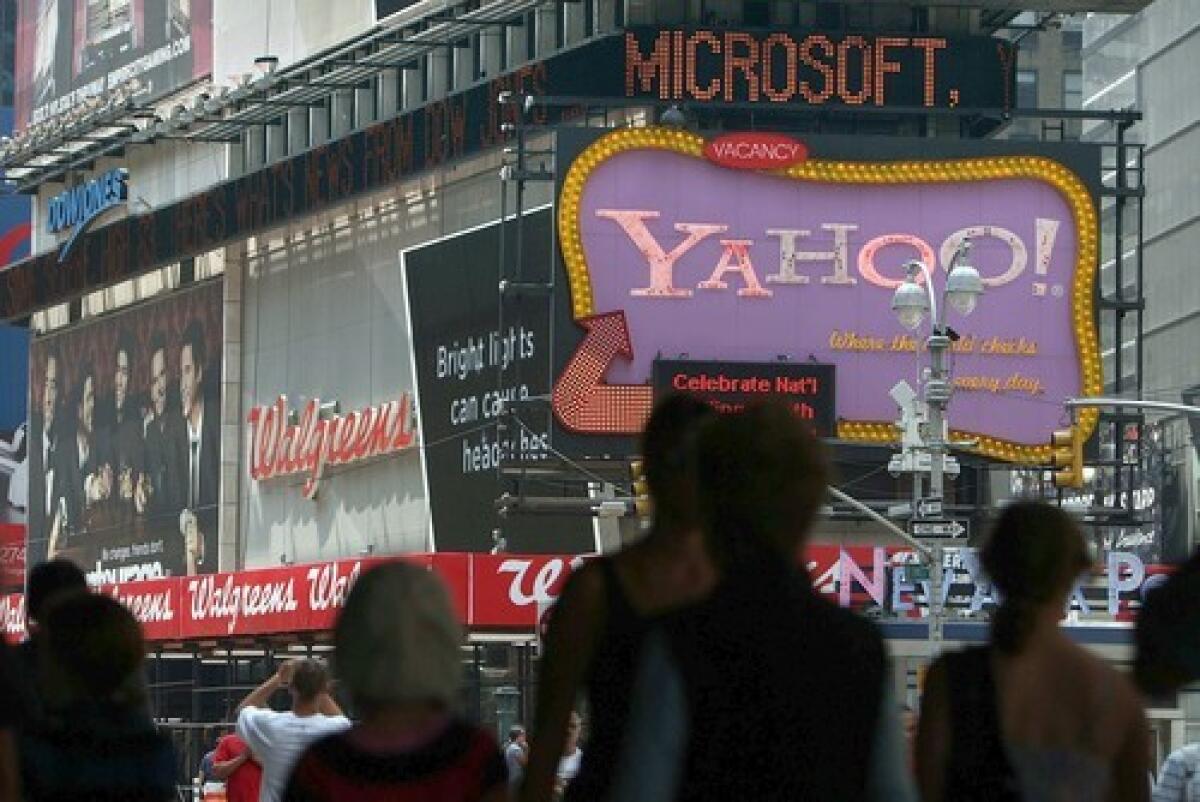 A Yahoo sign in New Yorks Times Square is topped by a news crawl announcing its search engine partnership with Microsoft.