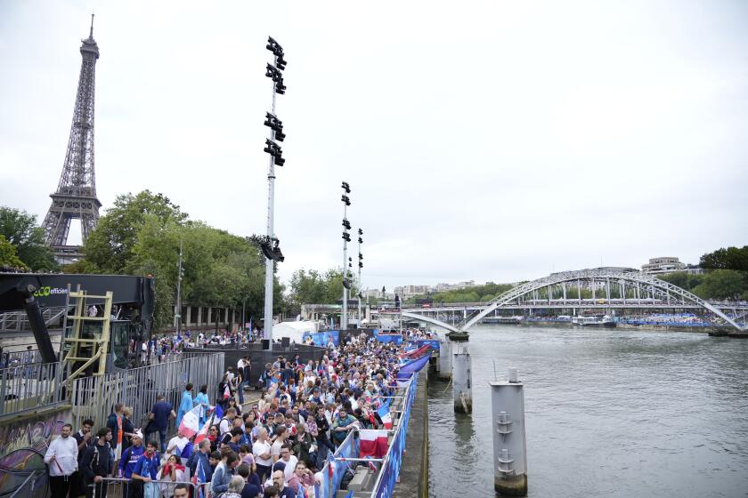 Los espectadores aguardan por el comienzo de la ceremonia de inauguración de los Juegos Olímpicos de París, el viernes 26 de julio de 2024. (AP Foto/Andrew Medichini)