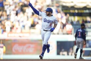 Los Angeles Dodgers' Max Muncy (13) celebrates as he runs the bases after hitting a home run.
