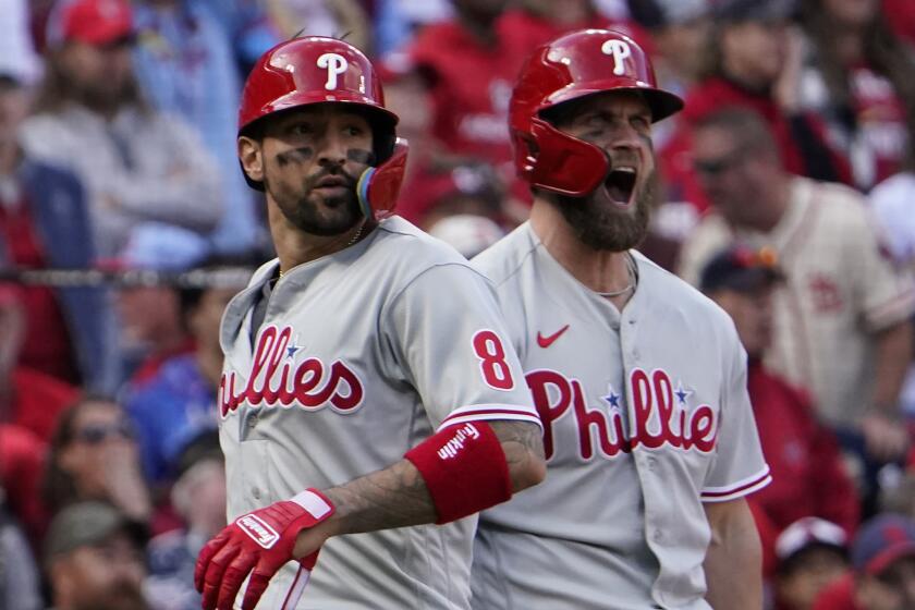 Philadelphia Phillies' Nick Castellanos (8) and Bryce Harper (3) celebrate after scoring on a single.