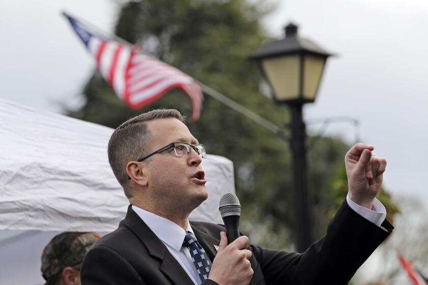 FILE - In this Jan. 18, 2019, file photo, state Rep. Matt Shea, R-Spokane Valley, speaks at a gun-rights rally at the Capitol in Olympia, Wash. The mayor and police chief of Spokane, Wash., are the latest to demand that the conservative state legislator resign from office after leaked emails revealed he sought to conduct surveillance on local progressive leaders. Mayor David Condon and Police Chief Craig Meidl on Tuesday, Aug. 20, 2019 denounced Shea, who wants to create a 51st state based on Christian principles. (AP Photo/Ted S. Warren, File)