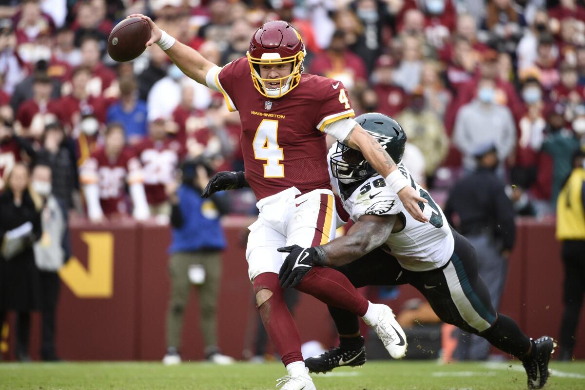 Philadelphia Eagles linebacker Genard Avery, right, sacks Washington Football Team quarterback Taylor Heinicke.