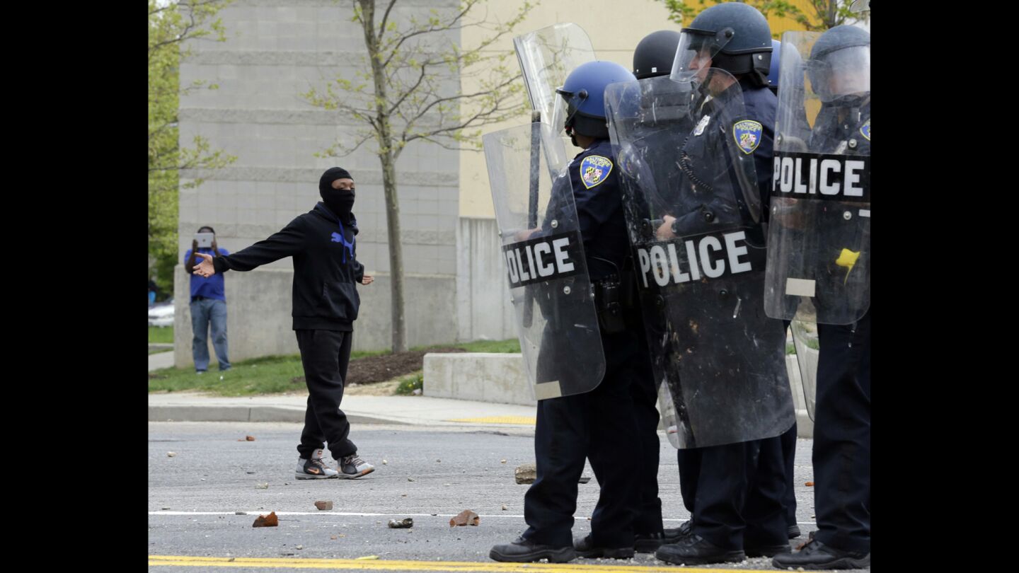 A demonstrator taunts police as they respond to thrown objects after the funeral of Freddie Gray in Baltimore.
