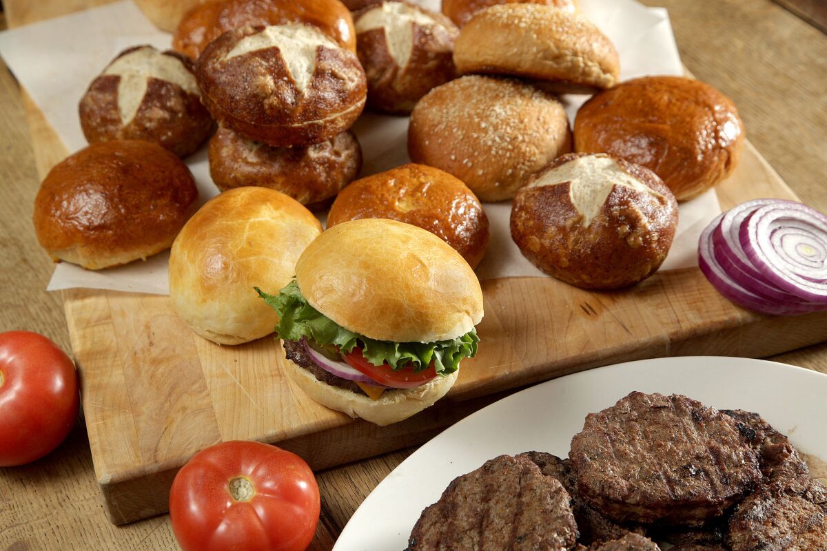 Recipes for 3 different homemade hamburger buns: brioche, pretzel and whole wheat. Hamburger is on a Brioche bun.