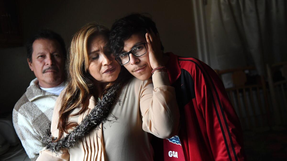 Student journalist Alex Medina, 16, right, poses with his parents Mario, left, and Candelaria at their home in Los Angeles.