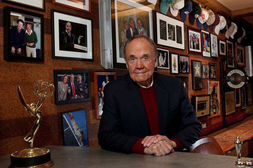 San Diego Padres broadcaster Dick Enberg at his home in La Jolla, amid framed photographs, including those of him with former broadcast partner Al McGuire.