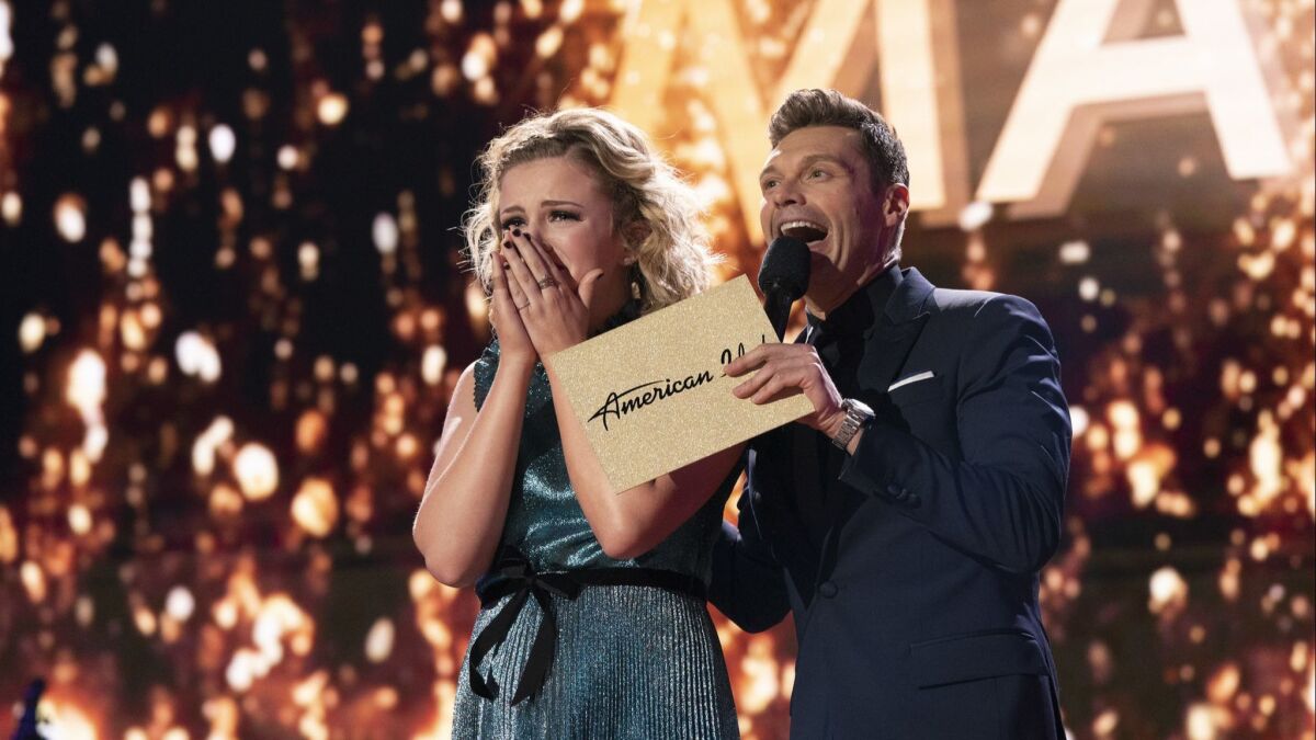 Maddie Poppe, left, reacts after being announced the winner of "American Idol" in Los Angeles. The singer-songwriter bested Caleb Lee Hutchinson and Gabby Barrett in the two-hour finale on ABC. (Mitch Haaseth/ABC via AP)