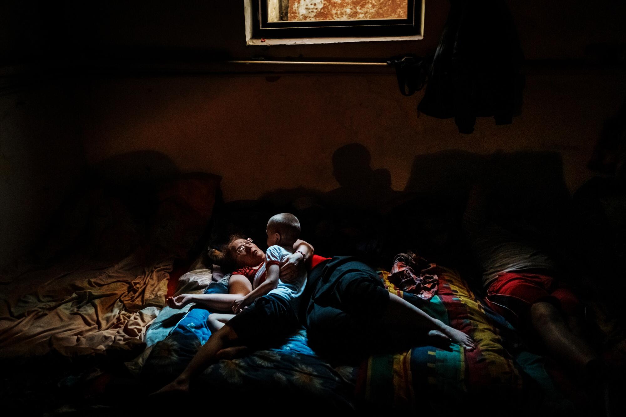 Natalia Tishenko comforts her son, Yaroslav, 7, in a bomb shelter near Velyka Novosilka, Ukraine
