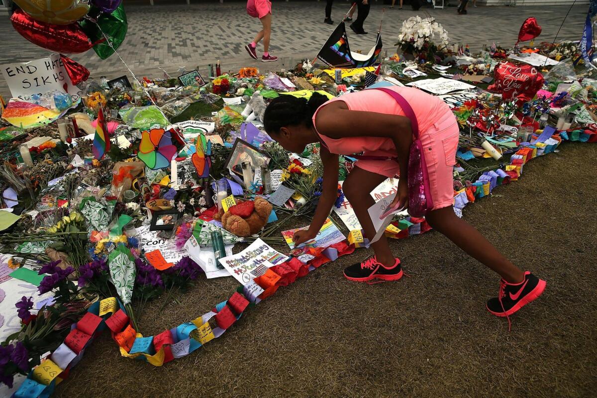 Elizabeth Rodriquez places a note on a memorial for those killed at the Pulse nightclub last Saturday night on Thursday.June 16, 2016 in Orlando, Florida. Omar Mir Seddique Mateen shot the victims in what appears to be an ISIS inspired attack in which 49 people were killed early Sunday and 53 people were wounded.