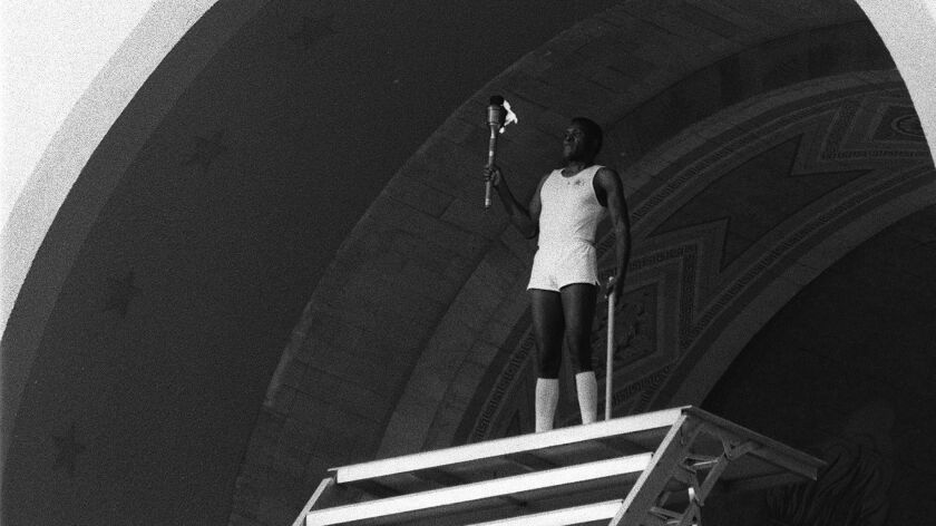 Rafer Johnson prepares to light the Olympic flame at the Los Angeles Memorial Coliseum to open the 1984 Summer Games.