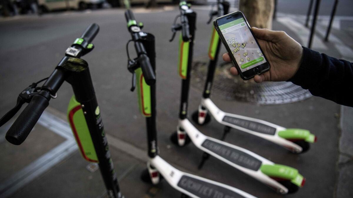 A man looks at the app that enables him to check on the availability of Lime's electric scooters.