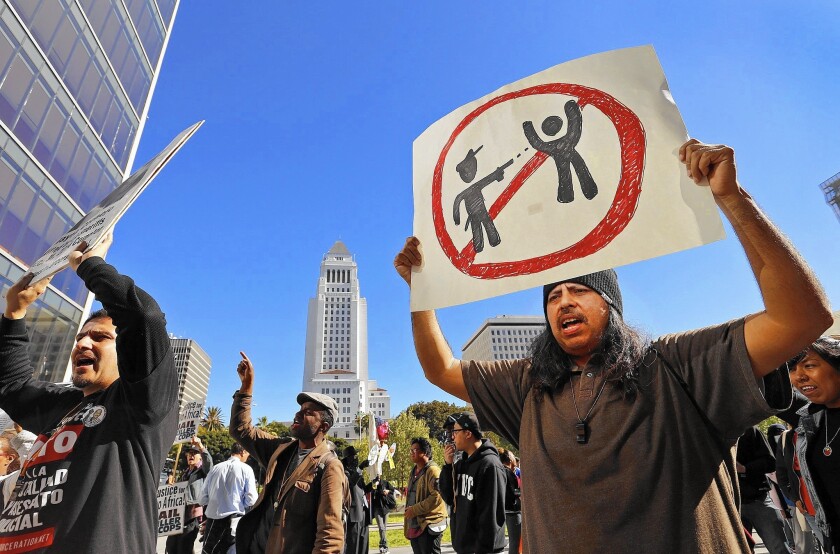 Victor Africa holds a sign during a protest march from skid row to LAPD headquarters.