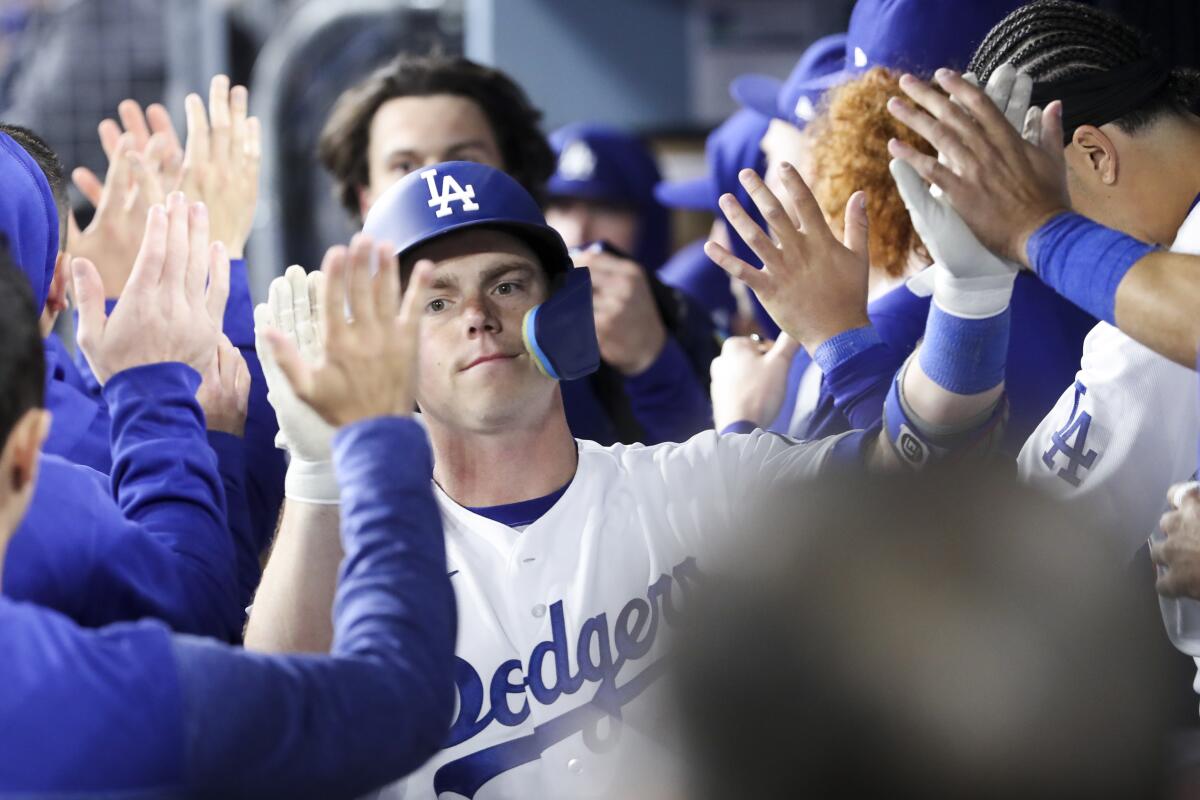 Dodgers catcher Will Smith celebrates in the dugout after driving in a run on a sacrifice fly.