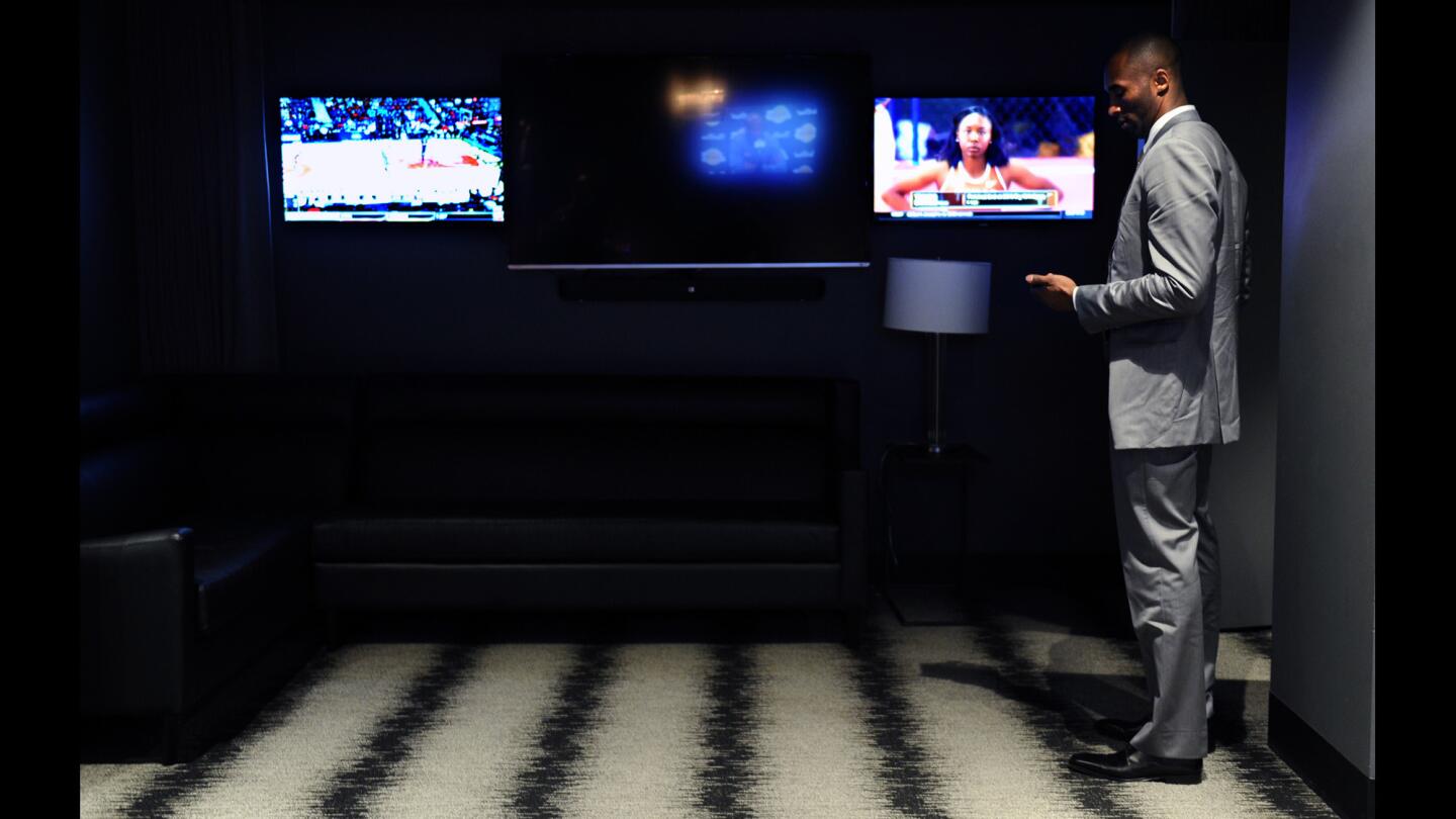 Lakers Kobe Bryant looks at his phone as he waits for guests in a private room before a game with the Knicks at the Staples Center.