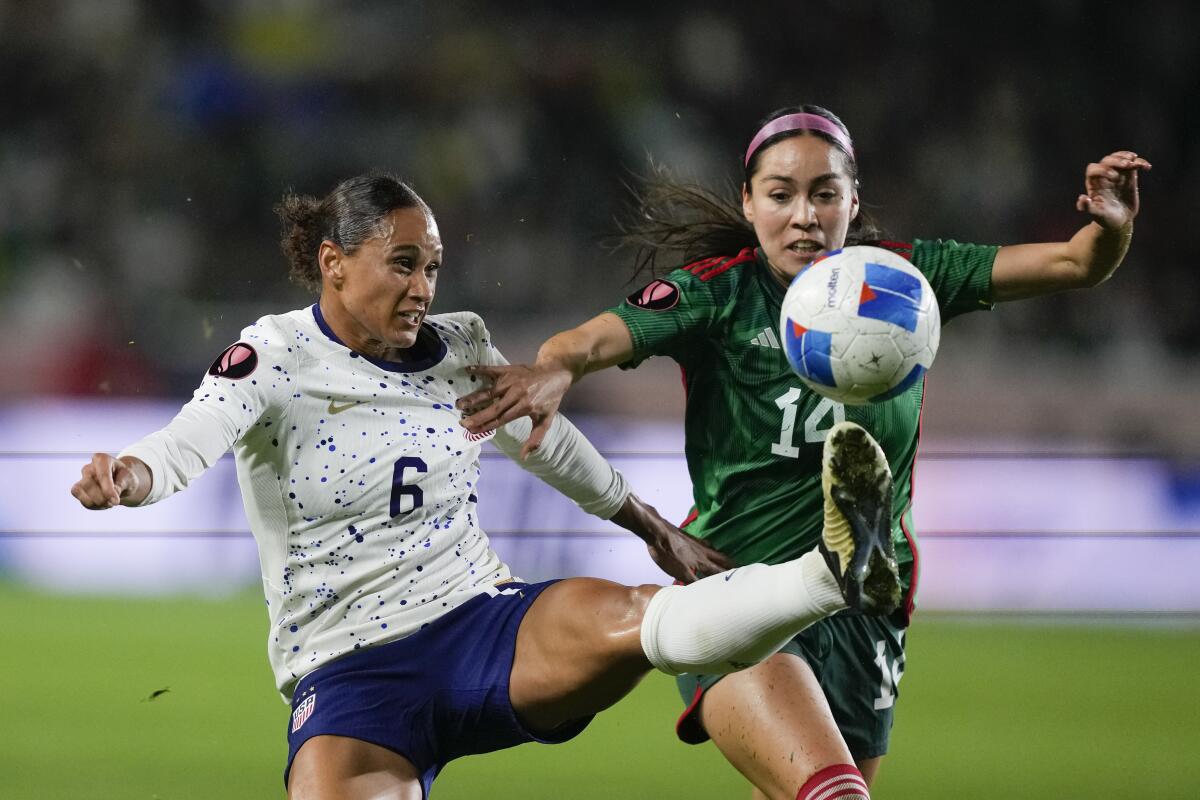 U.S. forward Lynn Williams, left, and Mexico defender Greta Espinoza, right, vie for the ball.