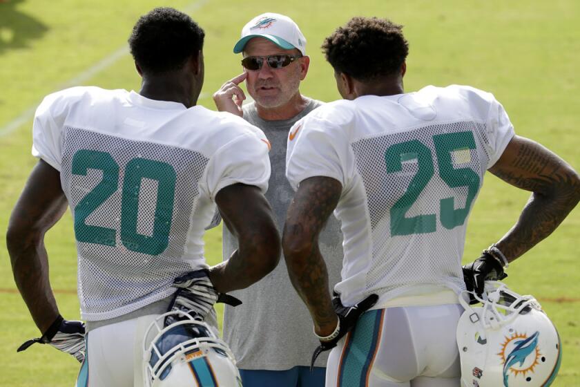 Former Miami Dolphins defensive coordinator Kevin Coyle, center, talks with safety Reshad Jones (20) and safety Louis Delmas (25) during an NFL training camp practice on Aug. 16.