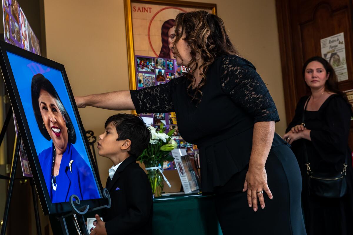 Sister Olga Molina Palacios with her 6-year-old son Moises Armando Palacios pays her respect at the funeral.