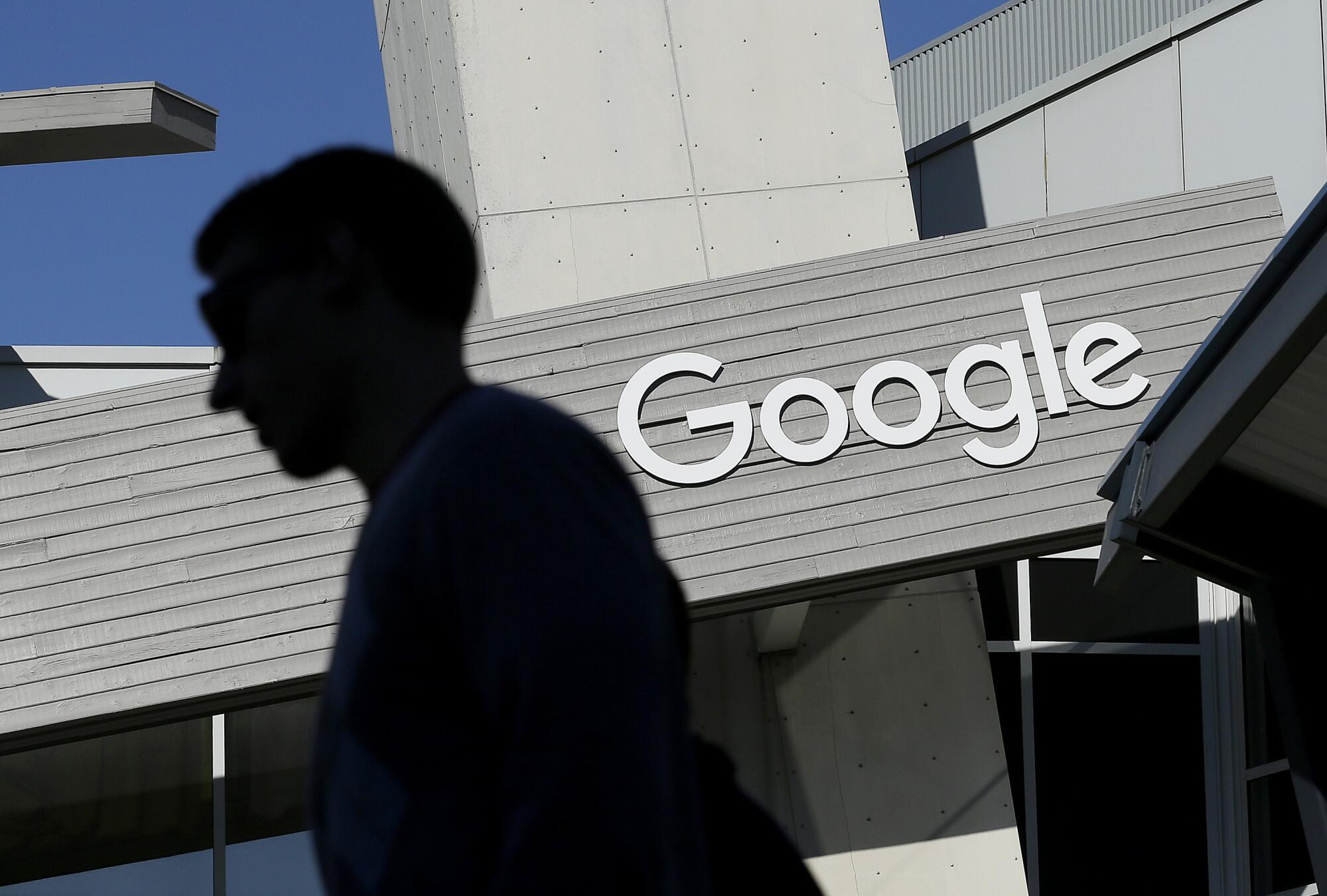 A man walks past a building on the Google campus in Mountain View, Calif. 