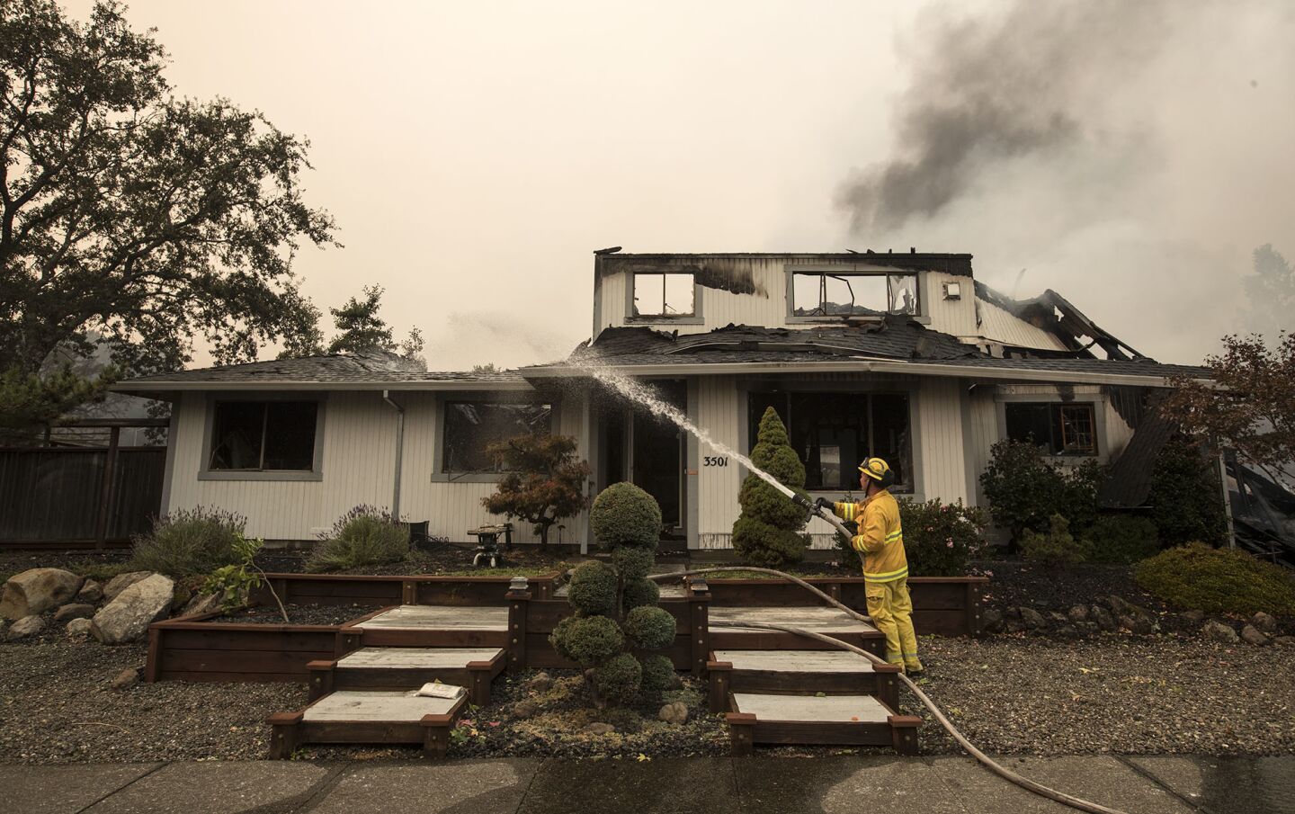A San Jose firefighter keep flames down at a home in Hidden Valley.