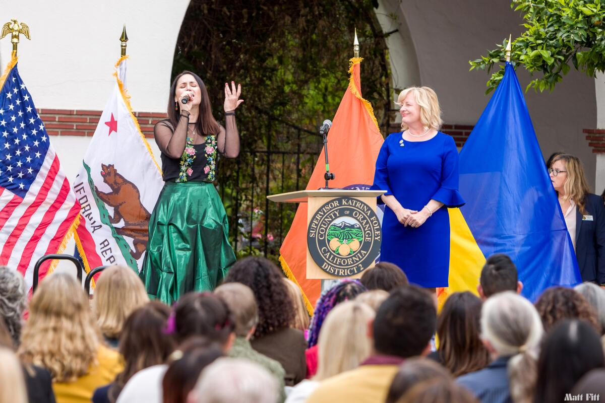 Supervisor Katrina Foley watches Asya Gorska, a vocalist from the Saint Andrew Ukrainian Orthodox Church, perform.