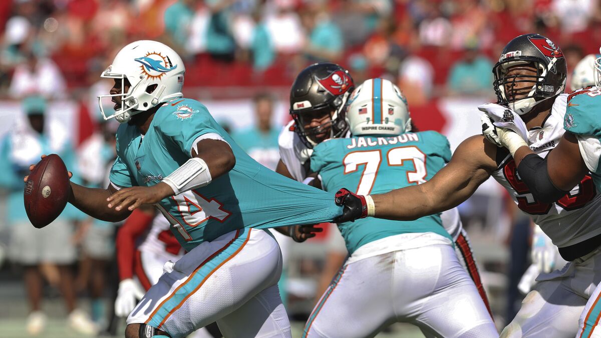 Tampa Bay Buccaneers defensive end Ndamukong Suh (93) grabs Miami Dolphins quarterback Jacoby Brissett (14) by the jersey during the second half of an NFL football game Sunday, Oct. 10, 2021, in Tampa, Fla. (AP Photo/Mark LoMoglio)