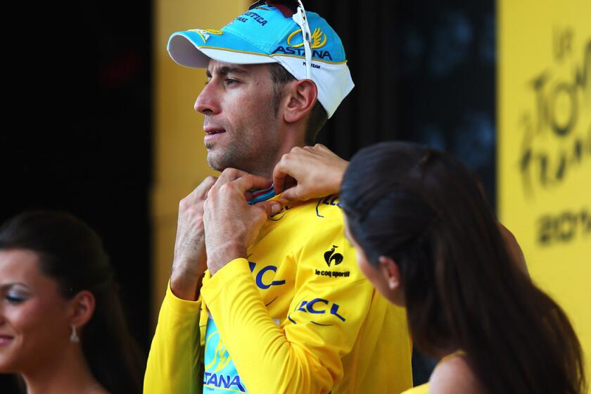 Vincenzo Nibali gets some help adjusting the collar of his yellow leader's jersey after the 12th stage of the Tou de France on Thursday in Saint-Etienne.