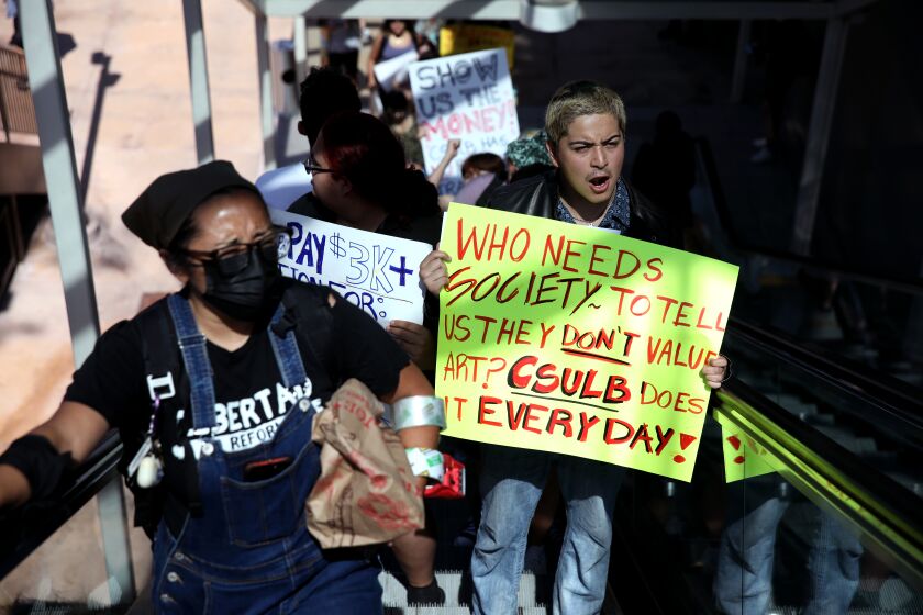 LONG BEACH, CA - SEPTEMBER 28: Kristen Huizar, 23, left, studying fine arts, and David Soto, 19, a political science student, along with their classmates protest on the Campus of California State University Long Beach on Wednesday, Sept. 28, 2022 in Long Beach, CA. Students at Cal State Long Beach hold their second walk out in less than a month over hot conditions inside classrooms. Focus on art buildings, which students say have no air conditioning and low ventilation. (Gary Coronado / Los Angeles Times)