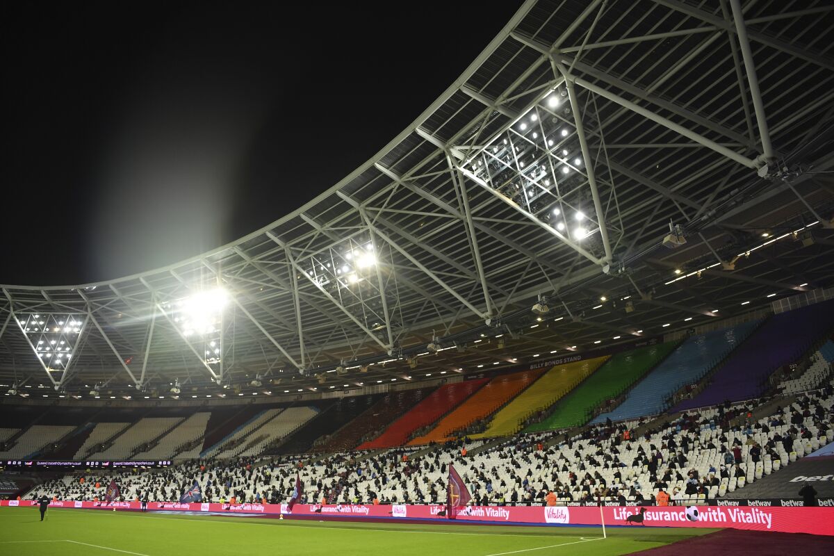 Fans are socially distanced as they wait for kick off ahead of the English Premier League soccer match between West Ham United and Manchester United at the London stadium in London, England, Saturday, Dec. 5, 2020. (Justin Setterfield/Pool Via AP)