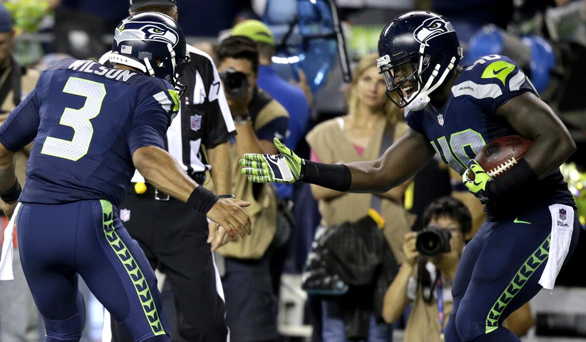 Seahawks quarterback Russell Wilson (3) celebrates with running back Derrick Coleman after the two connected for a 15-yard touchdown pass against the Packers in the fourth quarter Thursday night at CenturyLink Field in Seattle.