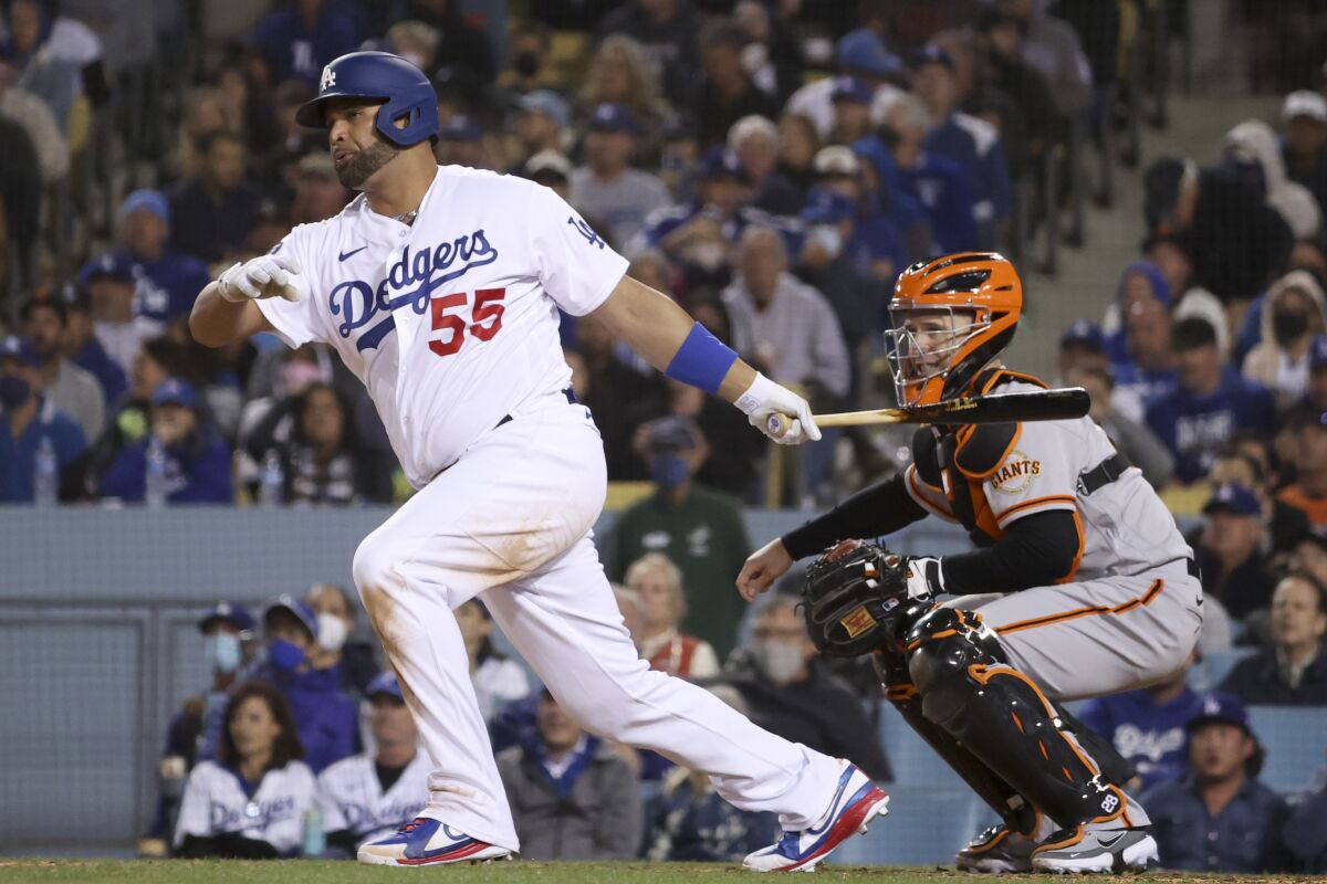 Dodgers' Albert Pujols follows through on a swing for a single.