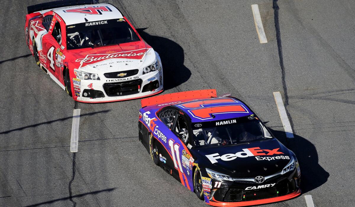 NASCAR driver Denny Hamlin races ahead of Kevin Harvick during the the STP 500 at Martinsville Speedway on Sunday.