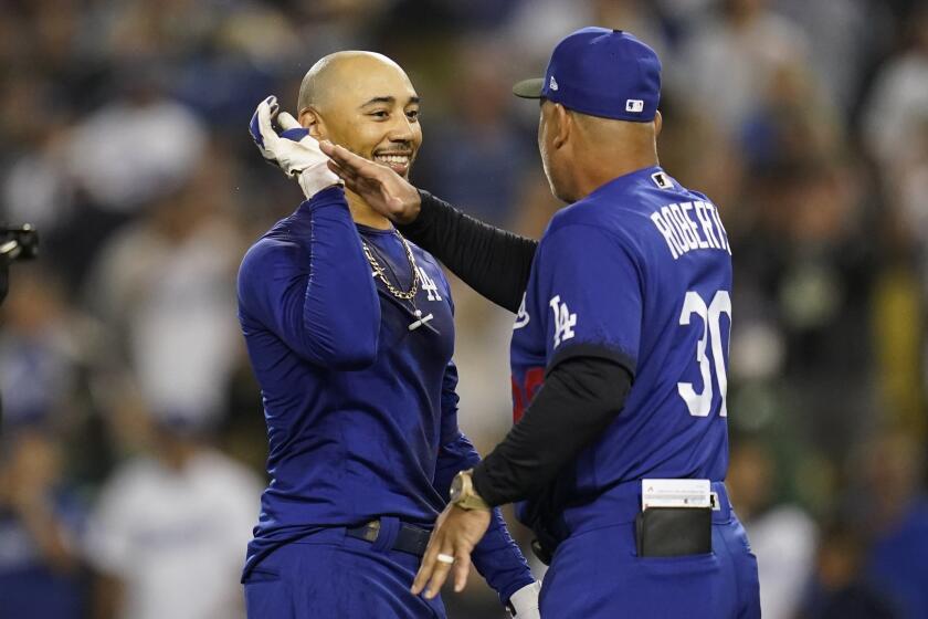Los Angeles Dodgers' Mookie Betts, center, is greeted manager Dave Roberts after he hit a walk-off single to win a baseball game 3-2 against the Arizona Diamondbacks in Los Angeles, Thursday, Sept. 22, 2022. Freddie Freeman scored. (AP Photo/Ashley Landis)