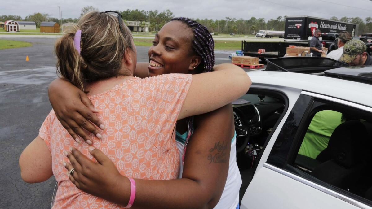 Shemika McCoo, right, embraces Kelly Shuler at Community Baptist Church in the aftermath of Hurricane Florence in Newport N.C. on Sept. 17.