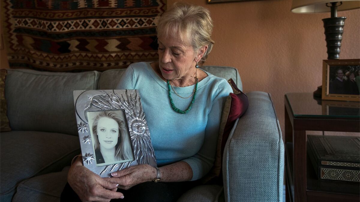 Sandy Sudweeks holds a framed photograph of her daughter, Adrienne “Sunny” Sudweeks, who was found raped and strangled to death in Adrienne’s Costa Mesa apartment in 1997.
