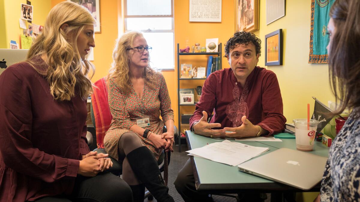 Samantha Erickson, left, of the Wiki Education Foundation; Tina Brock, a dean of the School of Pharmacy at UC San Francisco; and professor Amin Azzam discuss implementing the integration of Wikipeida pages on medical topics with students' work.