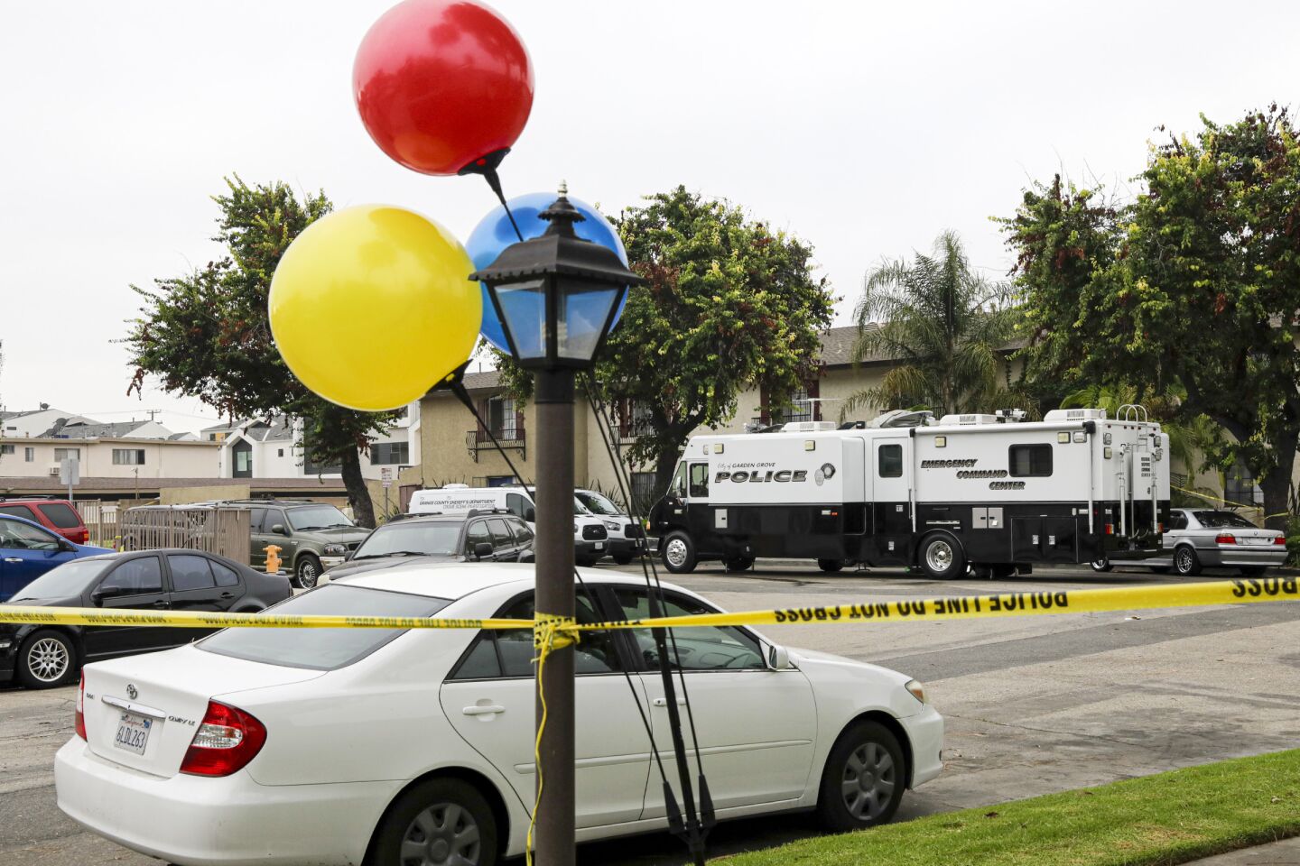 Balloons tied to a light post at the Garden Grove apartment complex where two people were fatally stabbed.
