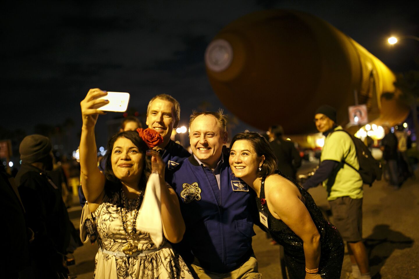 Space shuttle fans pose with astronauts Andrew J. Feustel, left, and Mike Fincke, center, as the last fuel tank moves along L.A. city streets to Exposition Park.