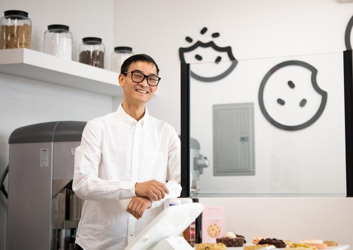 Kevin Nguyen, the owner of the newest Crumbl location in Fountain Valley, poses for a photo in the new cookie shop.