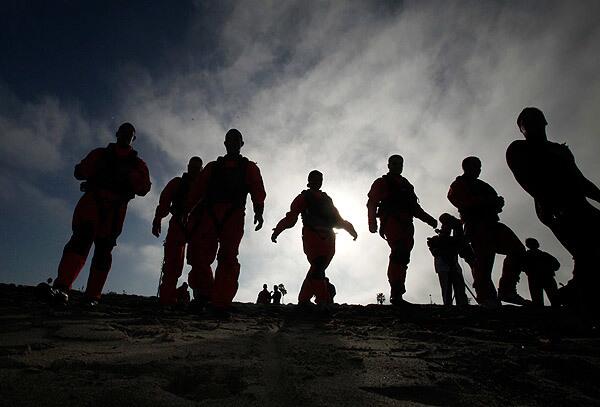 Coast Guard air crew members prepare to enter the water at Torrance Beach for their annual "wet drills." The air crews, pilots and rescue swimmers are given a chance to practice rescues, test their gear and refresh their skills.
