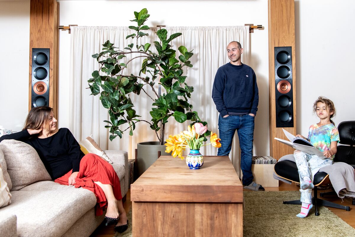 A woman, a man and a girl in the living room of their home.