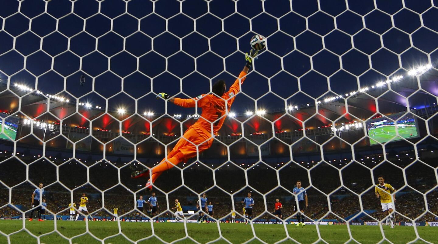 Colombia's Rodriguez scores a goal against Uruguay's goalkeeper Muslera during their 2014 World Cup round of 16 game at the Maracana stadium in Rio de Janeiro