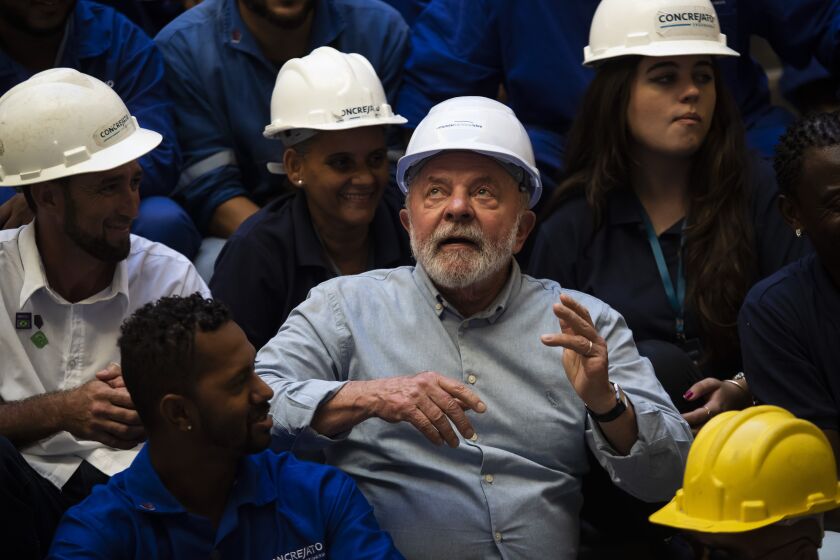 Brazil's President Luiz Inacio Lula da Silva looks up after taking having a photo taken with workers during a visit to the reconstruction works of the National Museum in Rio de Janeiro, Brazil, Thursday, March 23, 2023. The museum and a large part of its collection were destroyed in a 2018 fire. (AP Photo/Bruna Prado)